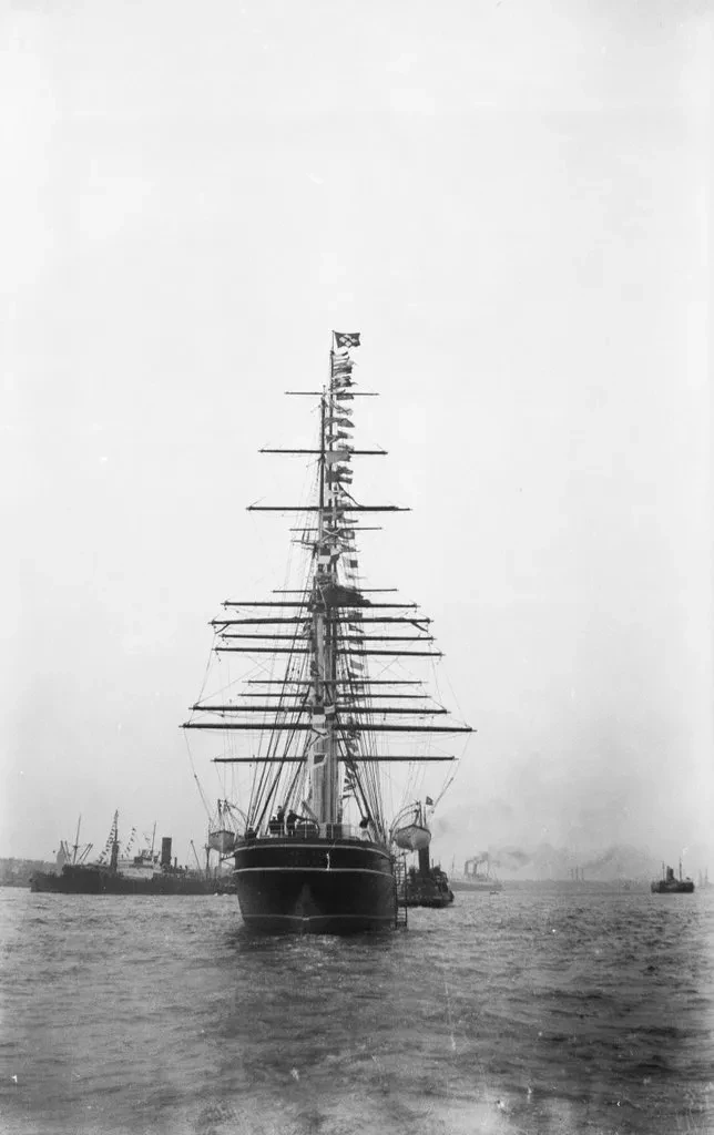Historic black and white photograph of Cutty Sark being towed on the River Thames