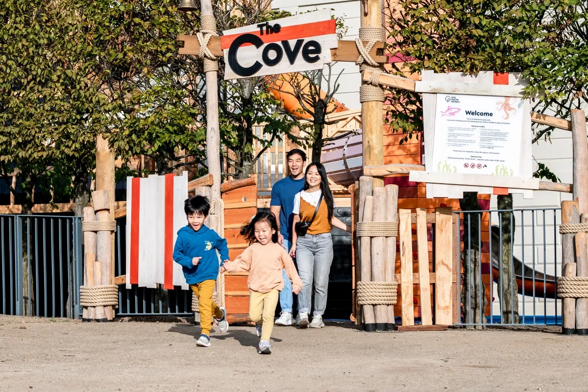 A family walks out of 'The Cove' playground.