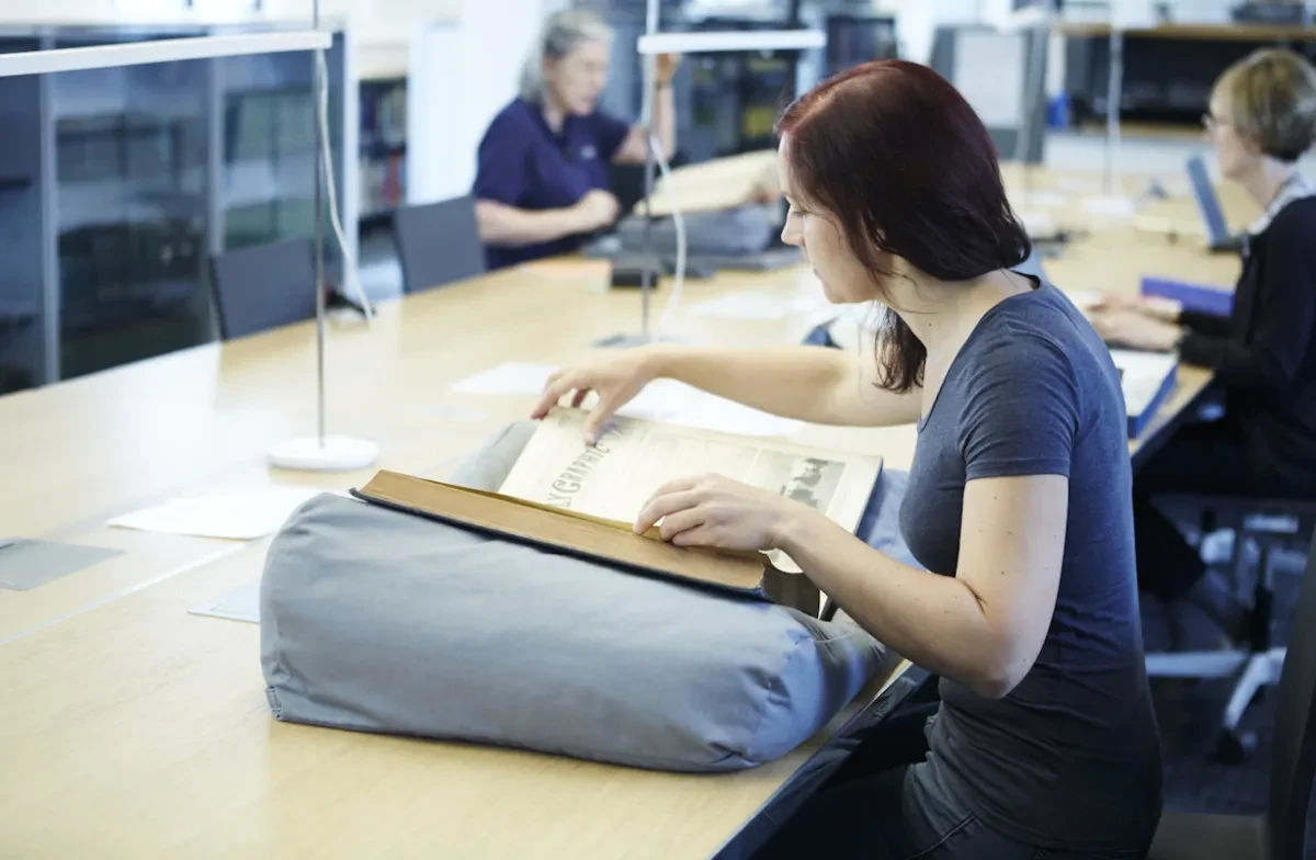 A visitor looks at a large book.