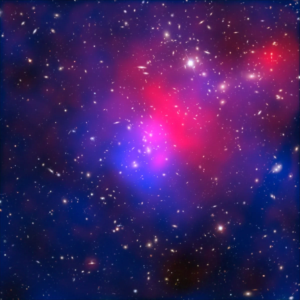 A pinkish blue haze in the centre of an inky night sky. This is visible light exposures of galaxy cluster Abell 2744 taken by the NASA/ESA Hubble Space Telescope and the European Southern Observatory’s Very Large Telescope