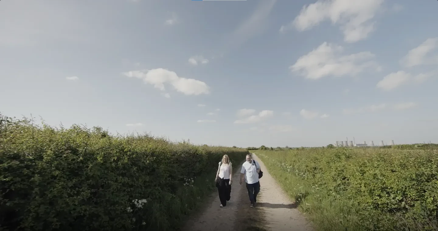 Darren and Claire Flinders walking along countryside path surrounded by greenery