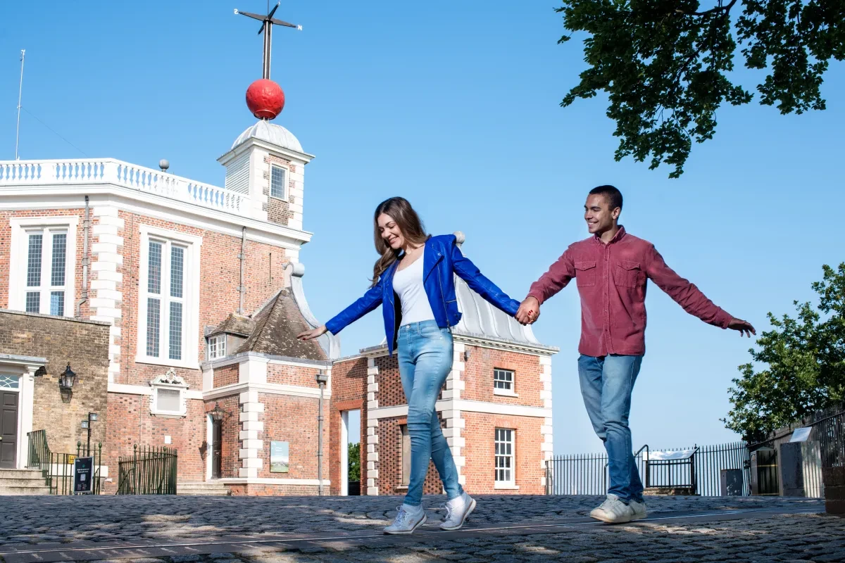 Two people standing on the Meridian Line at the Royal Observatory