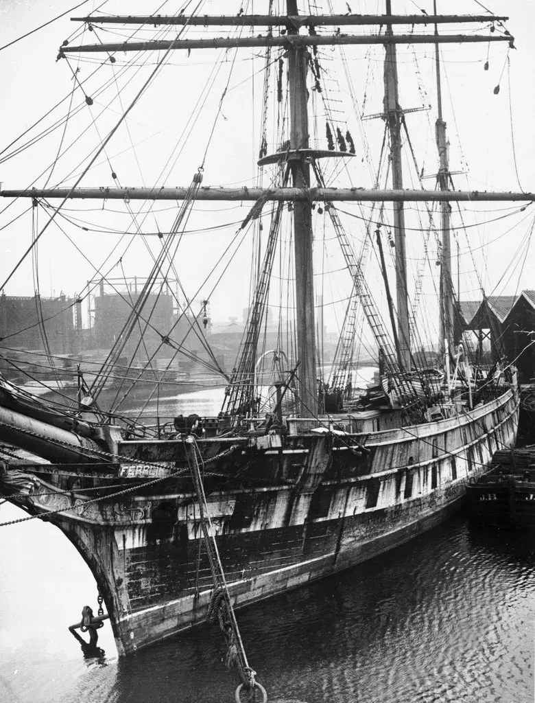 Black and white historic photograph of Cutty Sark in need of repair in a dock