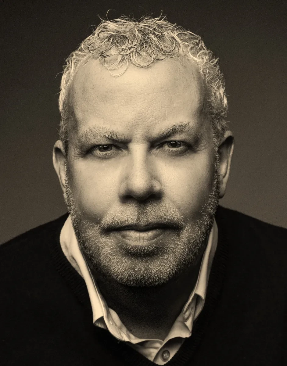 A moody, black and white portrait photograph of historian Howard Fuller