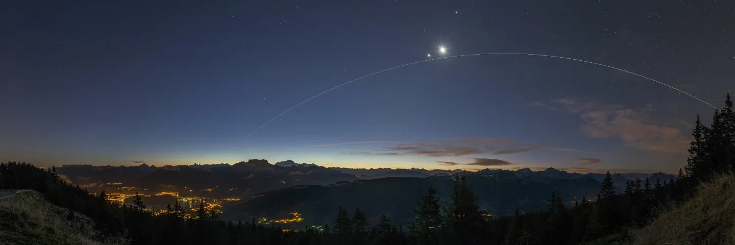 Image of alpine landscape with International Space Station, Venue and the Moon in the sky