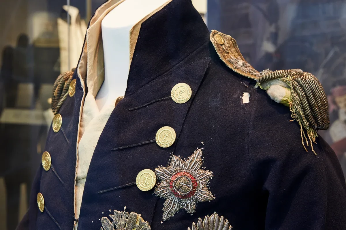 A close-up of Nelson's Trafalgar Coat, it is dark blue with gold details.