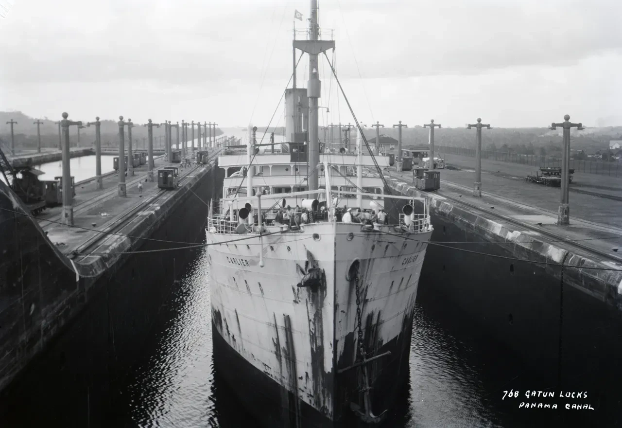 Historic black and white photograph of a cargo ship in the Gatun Locks of the Panama Canal