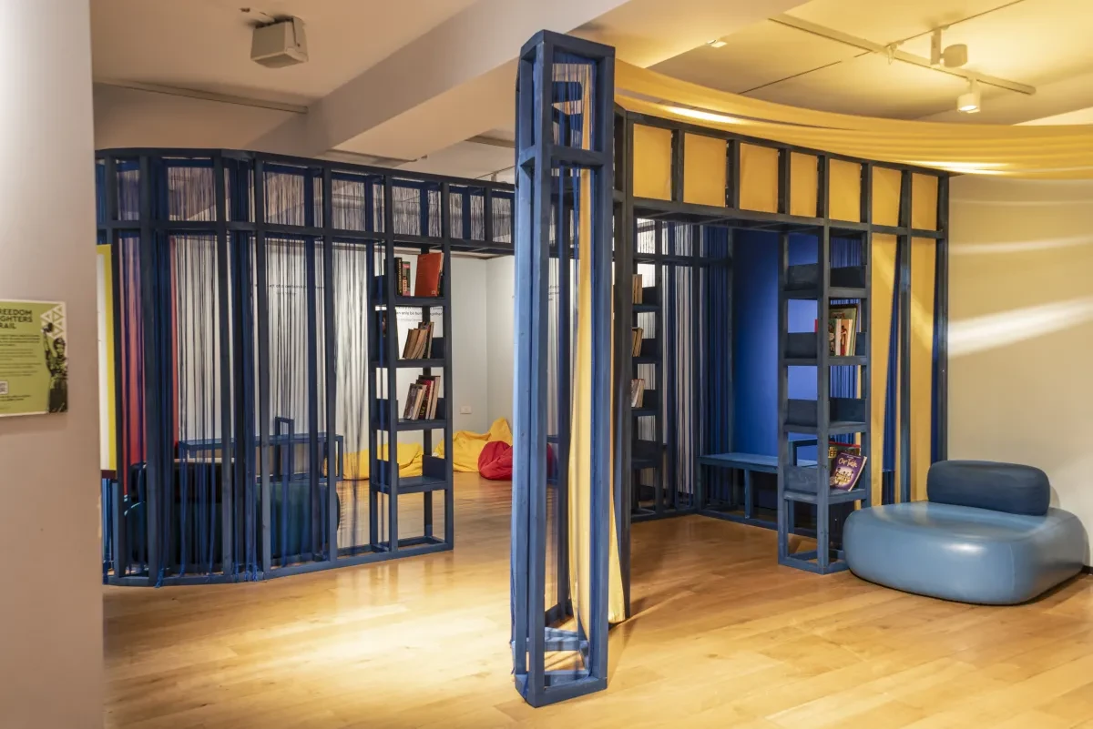 A section of the Atlantic Worlds gallery with blue bookshelves and sofas