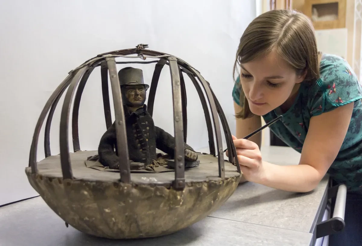 A museum conservator examines an object from the collection at Royal Museums Greenwich