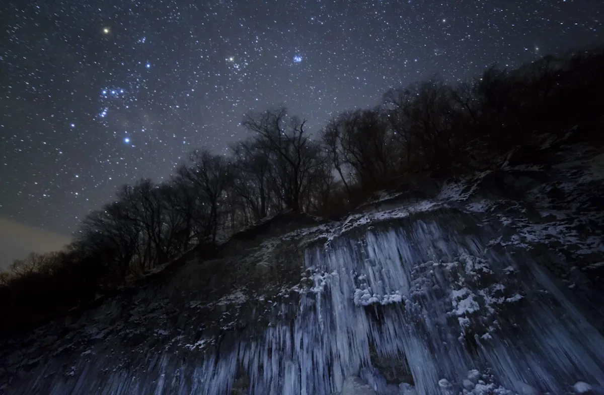 Astronomy photograph of a starry sky above an icefall.